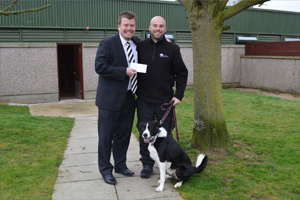 Managing Director, Haydn Davies, hands over a cheque to Neil and Sam the collie of Mrs Murray's Home for Stray Dogs and Cats. Managing Director, Haydn Davies, hands over a cheque to Neil and Sam the collie of Mrs Murray's Home for Stray Dogs and Cats.